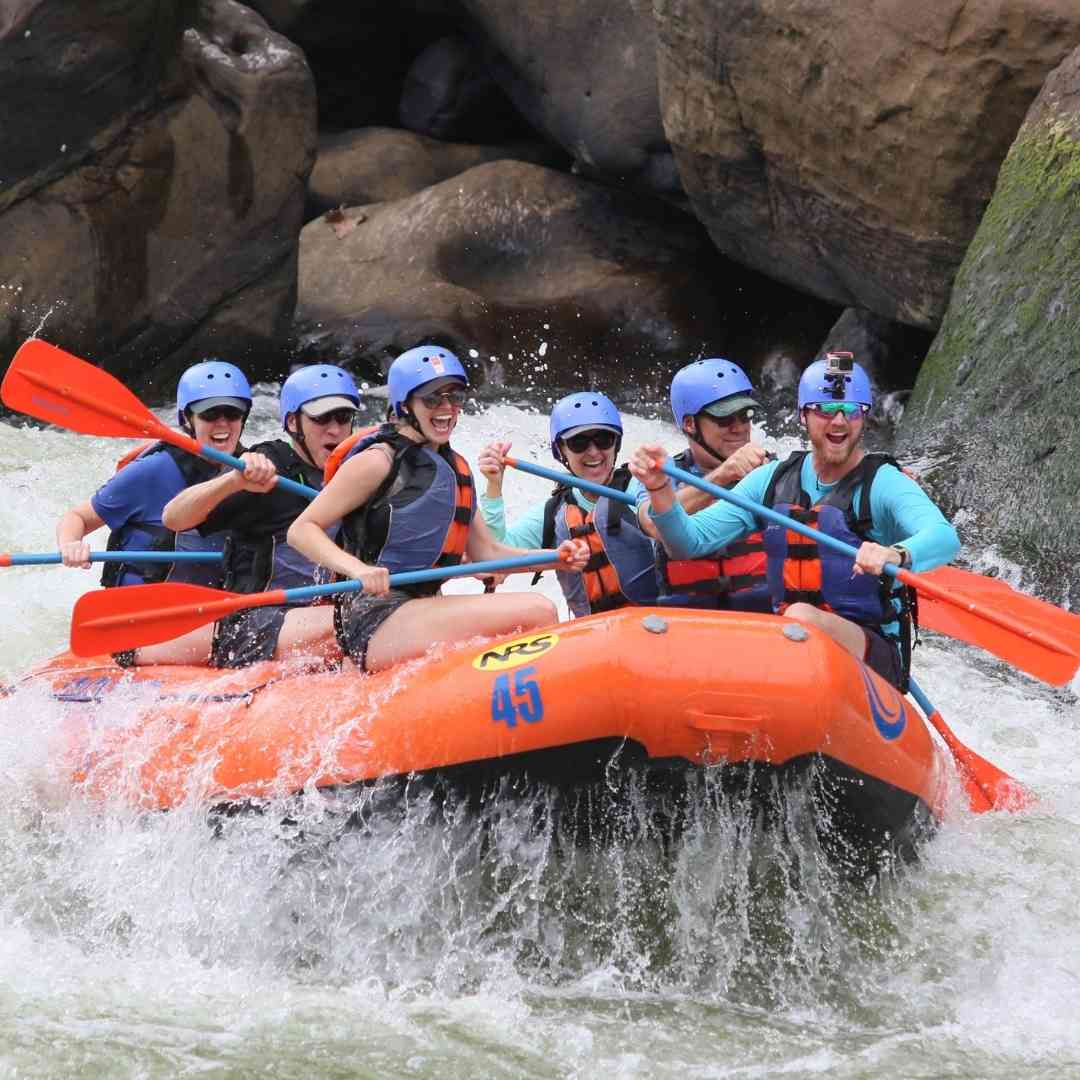 A group of people smiling while white water rafting