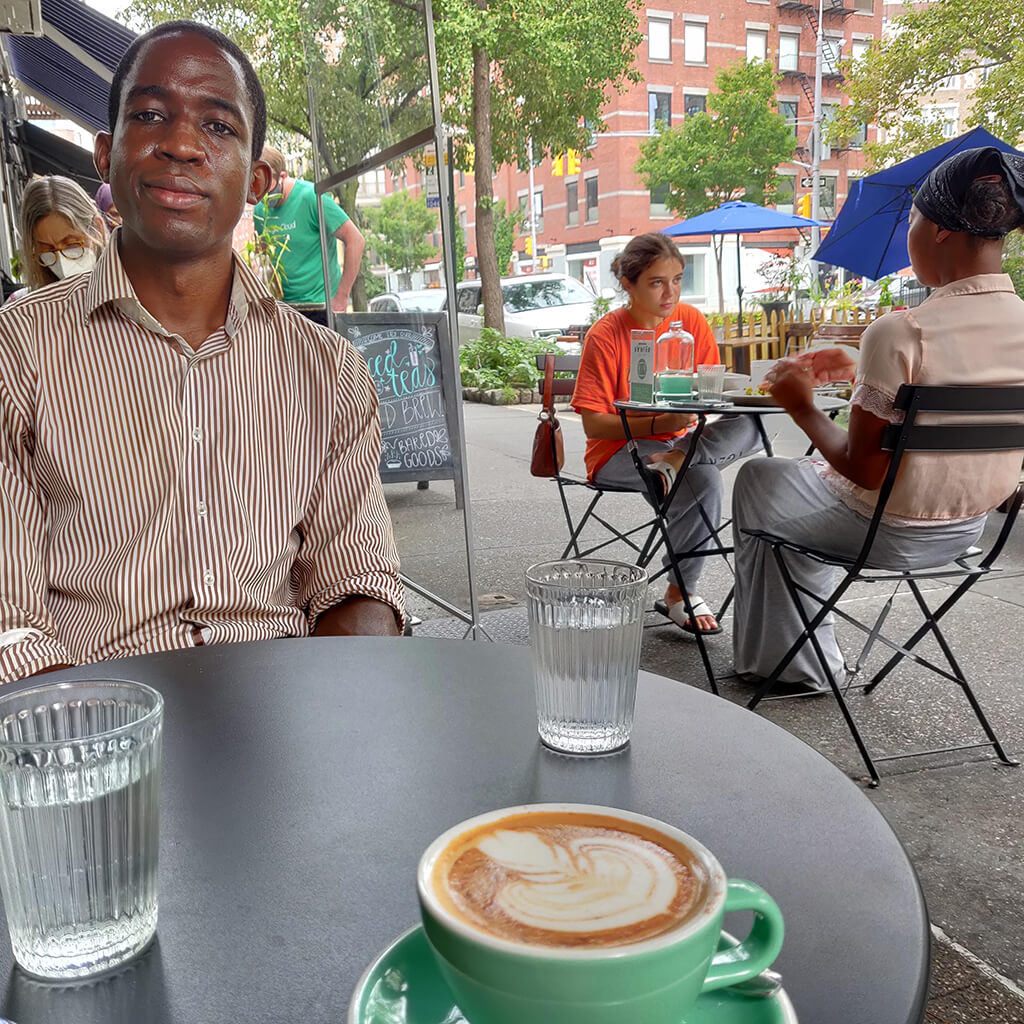 Man at table on sidewalk café with cup of coffee